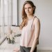 A young woman stands next to a sunlit windowsill, creating a tranquil ambiance.